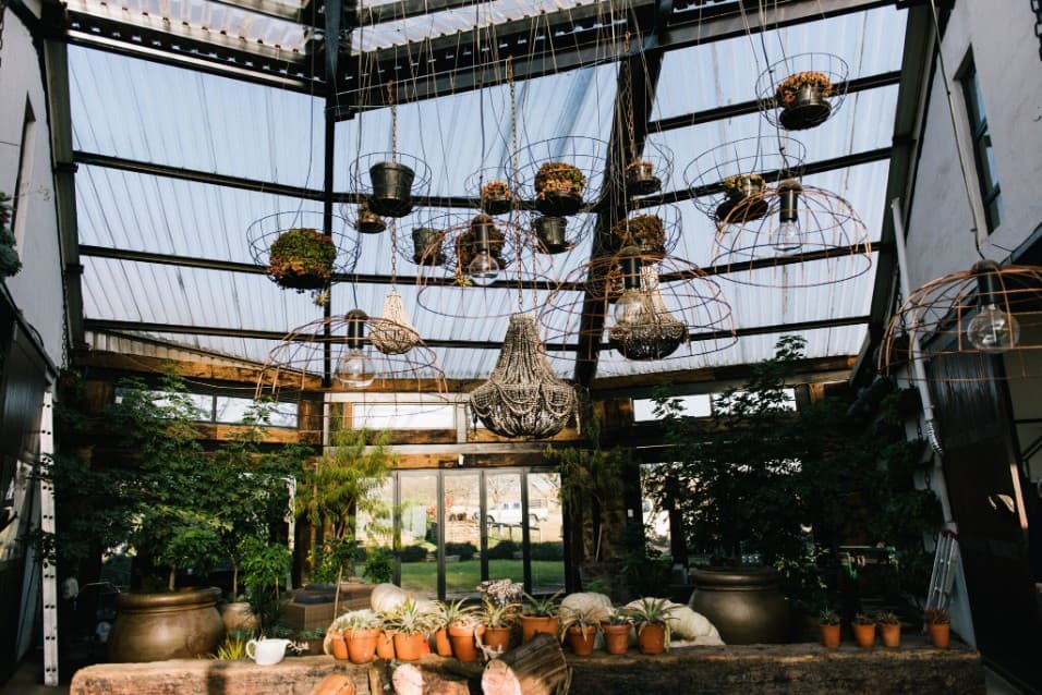 Glass conservatory with hanging lanterns and pot plants