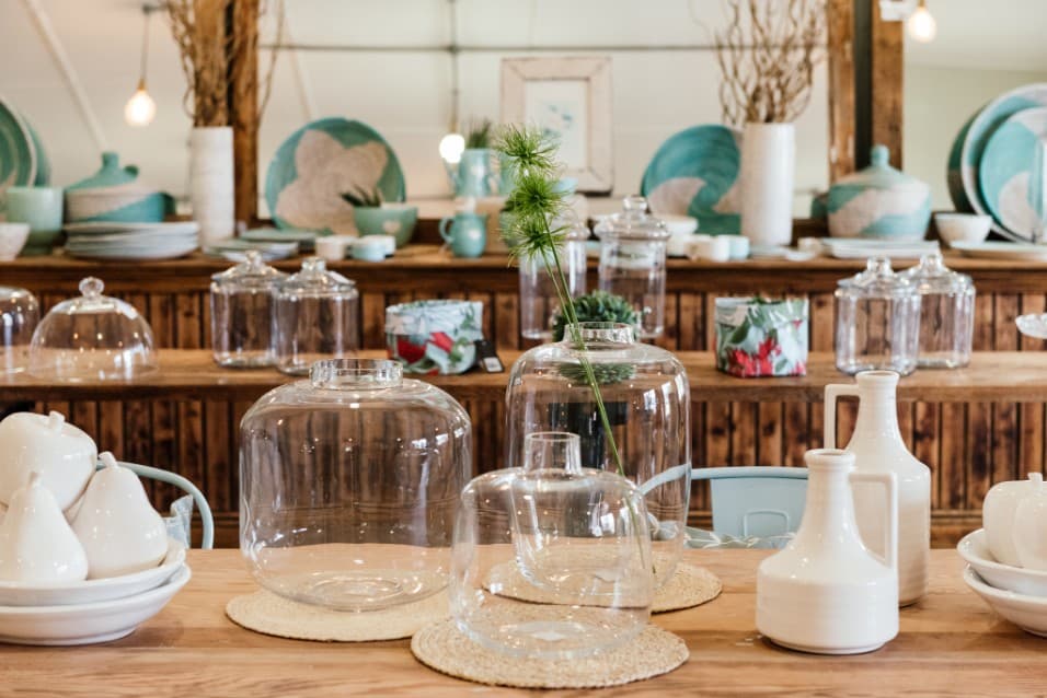 Glass cloches and ceramics displayed on a wooden table