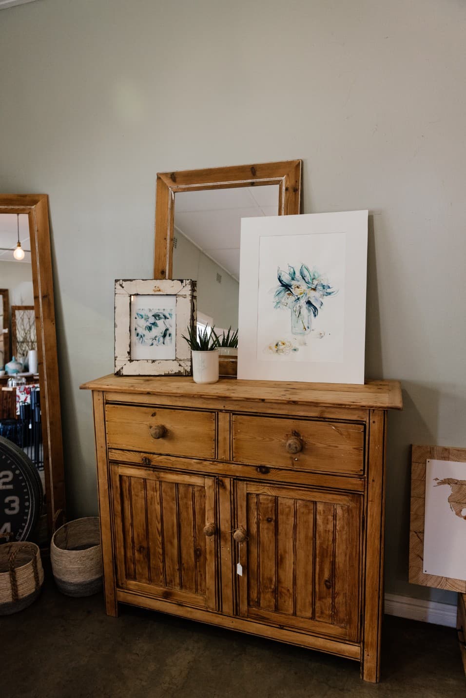 Framed botanical watercolours on a wooden dresser