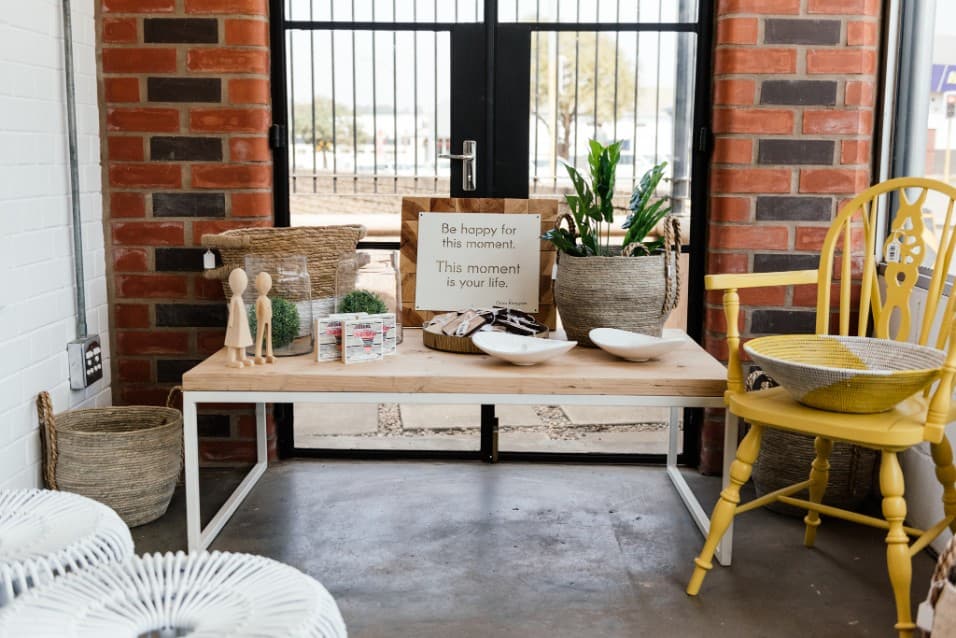 Shop entrance with a table, plants and a yellow chair