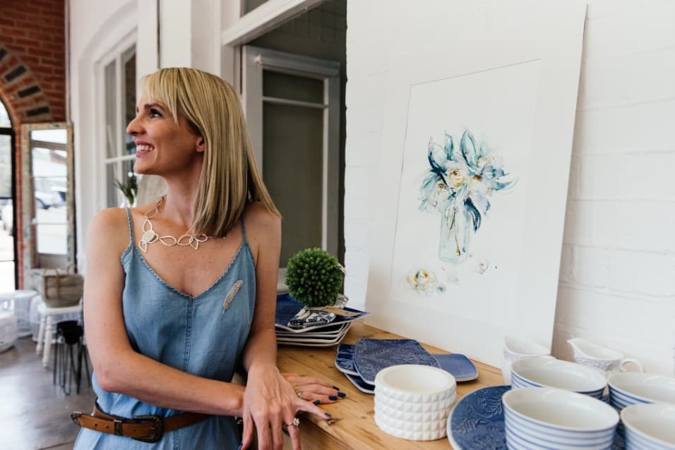 Woman beside a floral watercolour and blue and white crockery