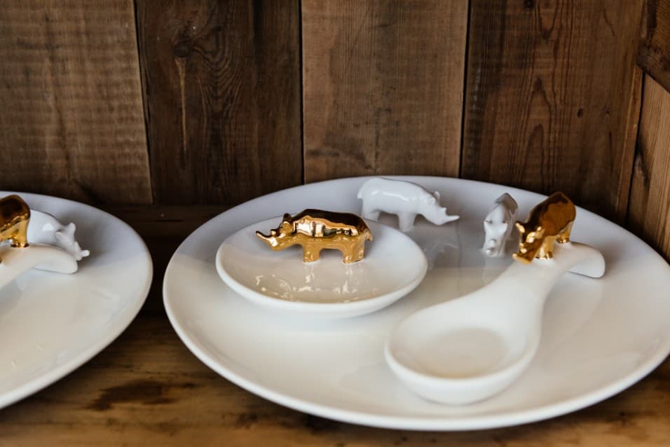 White ceramic dishes holding small gold and white animal figures