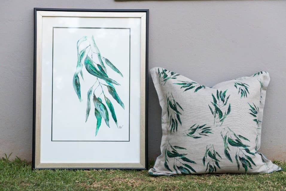 Framed gum-leaf watercolour beside a matching cushion