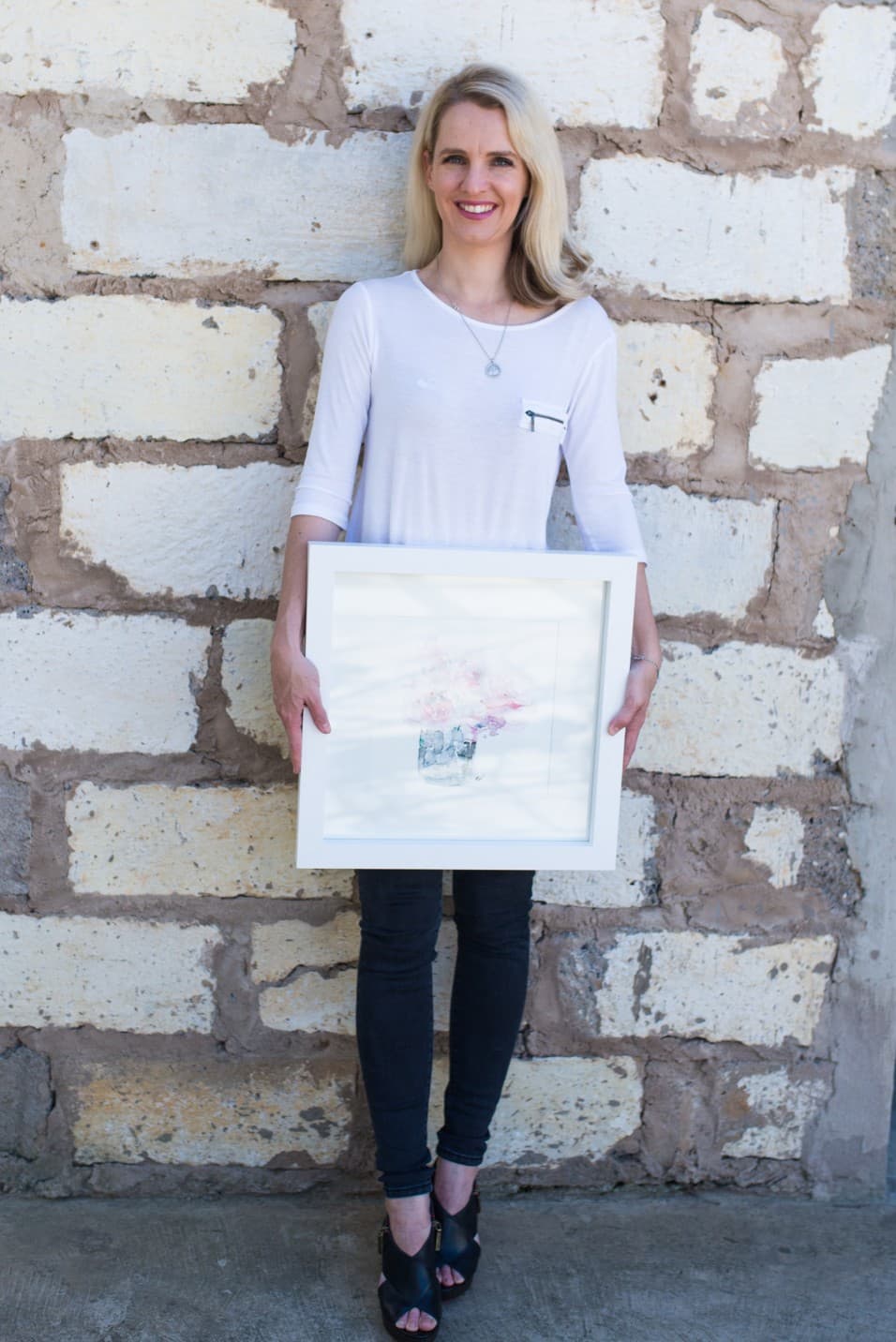 Woman holding a framed watercolour of roses