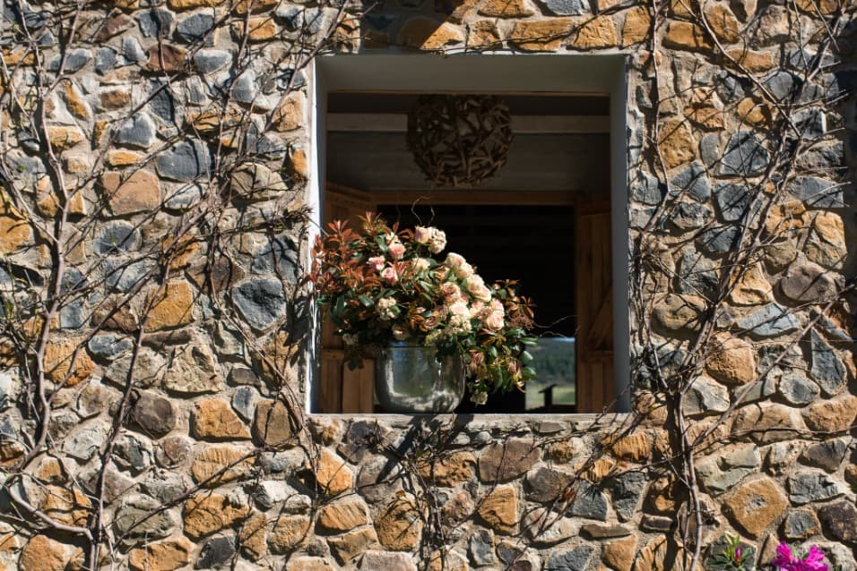 Flower arrangement in a window of a stone wall