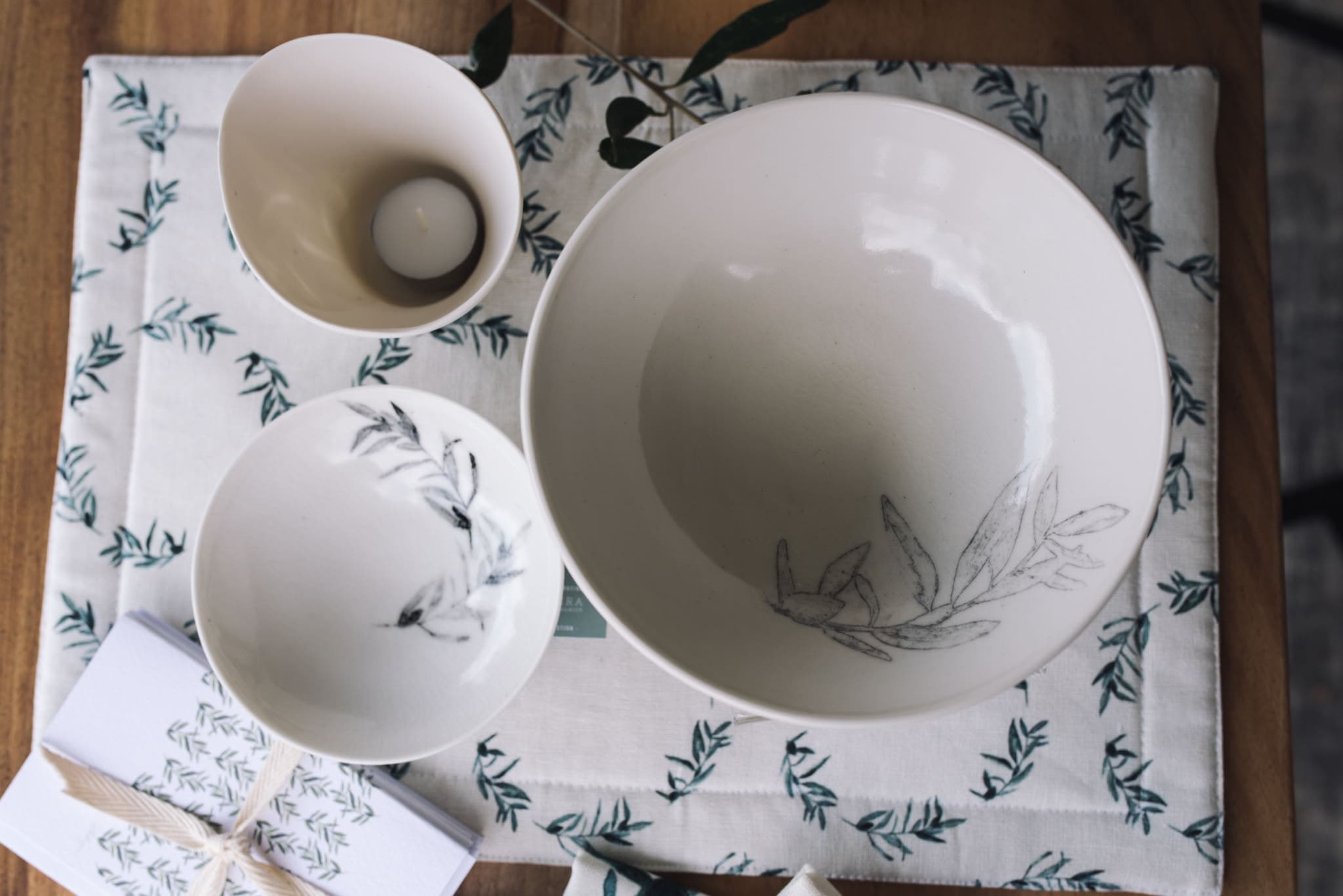 Olive-branch ceramic bowls on an olive-print place mat